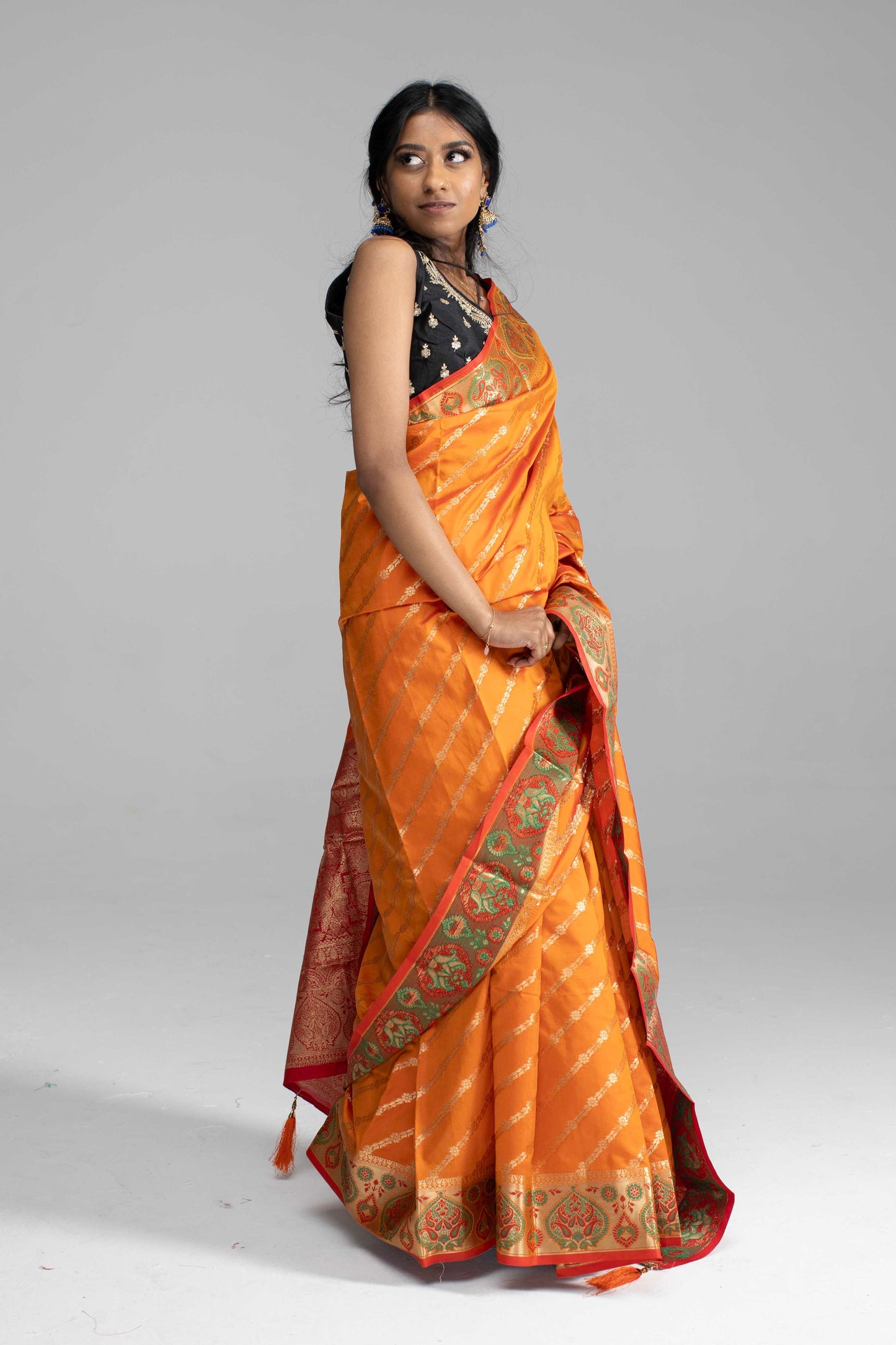 Orange Saree, featuring gold diagonal lines and a beautifully crafted border