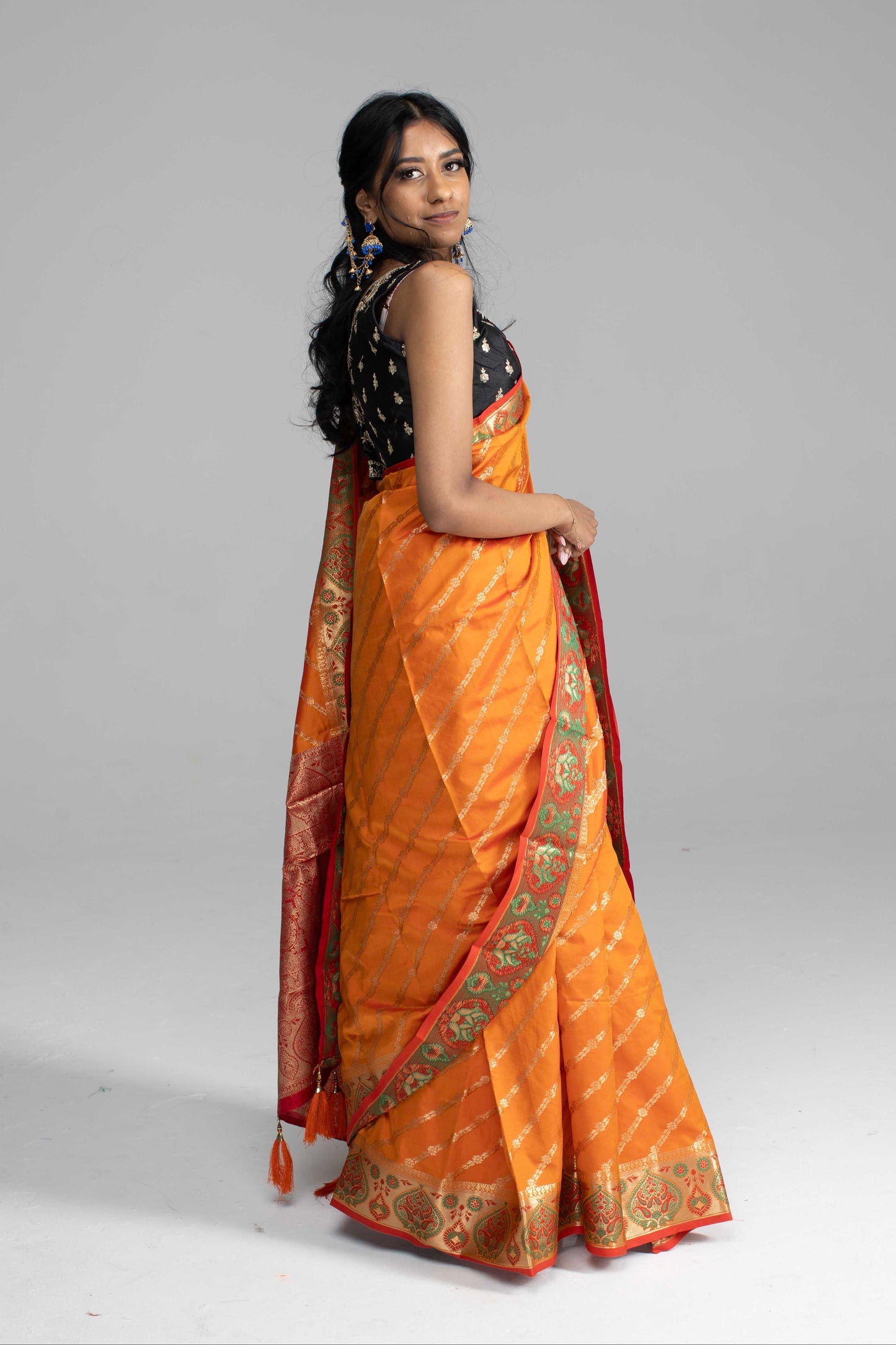 Orange Saree, featuring gold diagonal lines and a beautifully crafted border
